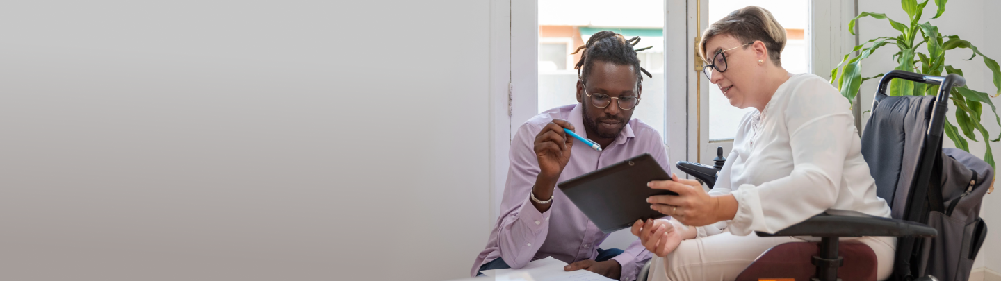 young boy in a wheelchair smiling at the camera while playing with colored blocks